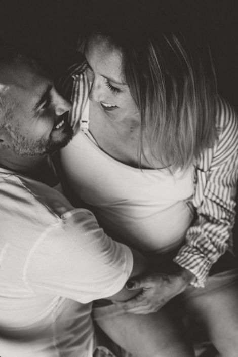 Amoureux et futurs parents enlacés, en noir et blanc
