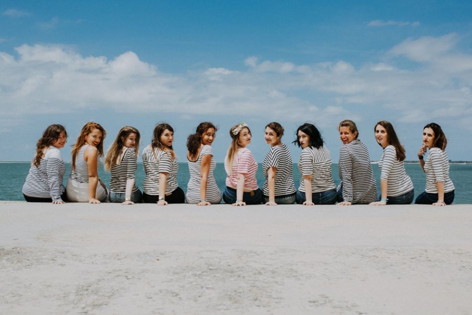 Dix copines et la future mariée assises au bord de l'eau se retournent, à Arcachon dans les Landes