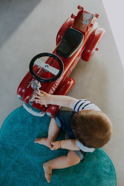 Enfant et sa voiture rétro rouge en bois, près de Auch
