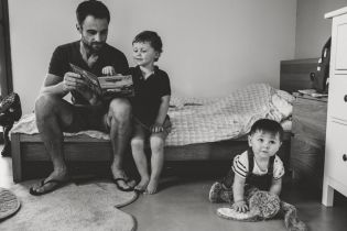 Papa et ses deux fils en train de lire une histoire à Auch