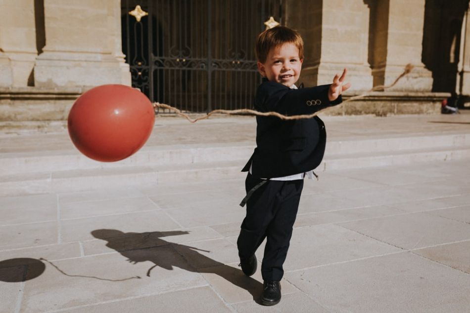 Sortie de messe de mariage, petit bonhomme jouant avec un ballon rouge sur le parvis de la cathédrale de Auch