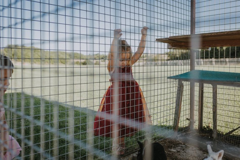 Enfant fascinée par les lapins au domaine de Baulieu durant un mariage champêtre