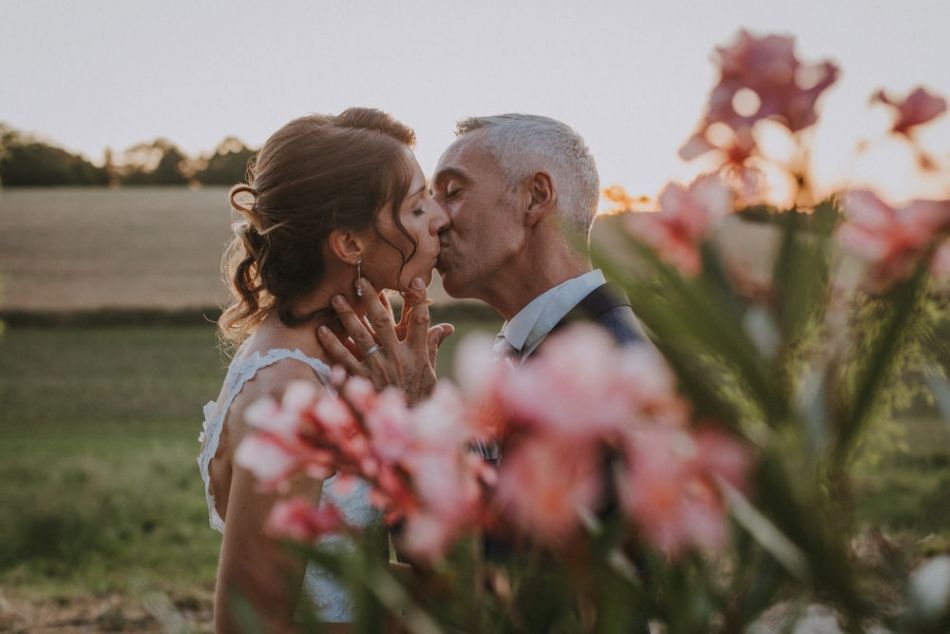 Les mariés amoureux s'embrassent durant le coucher de soleil au domaine de Baulieu