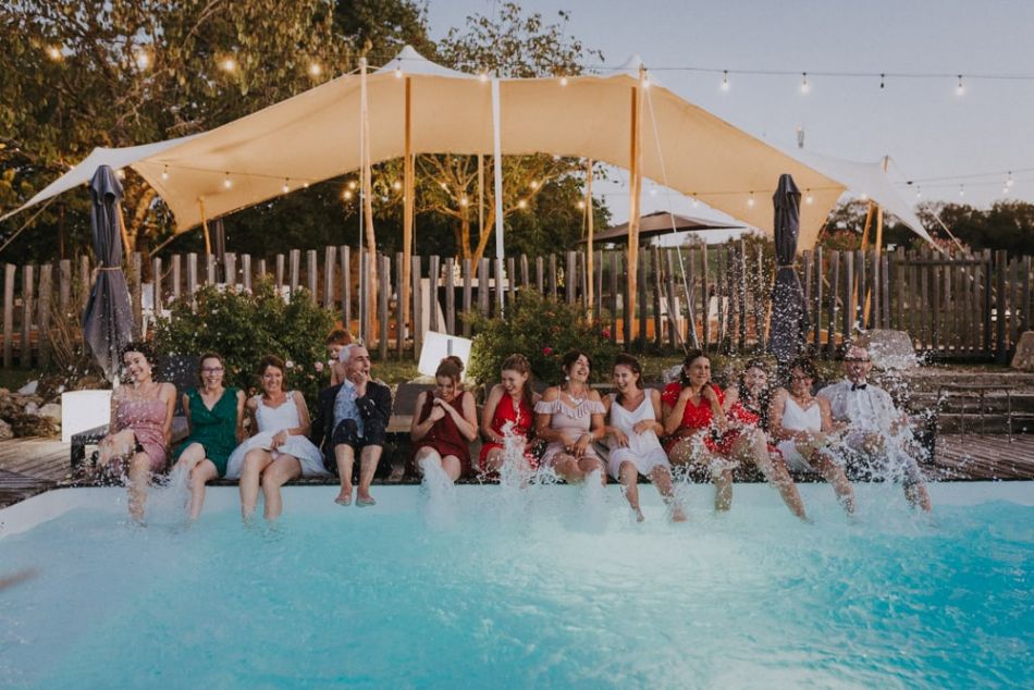 Mariés et invités, les pieds dans l'eau, s'éclaboussant, au domaine de Baulieu à Auch dans le Gers