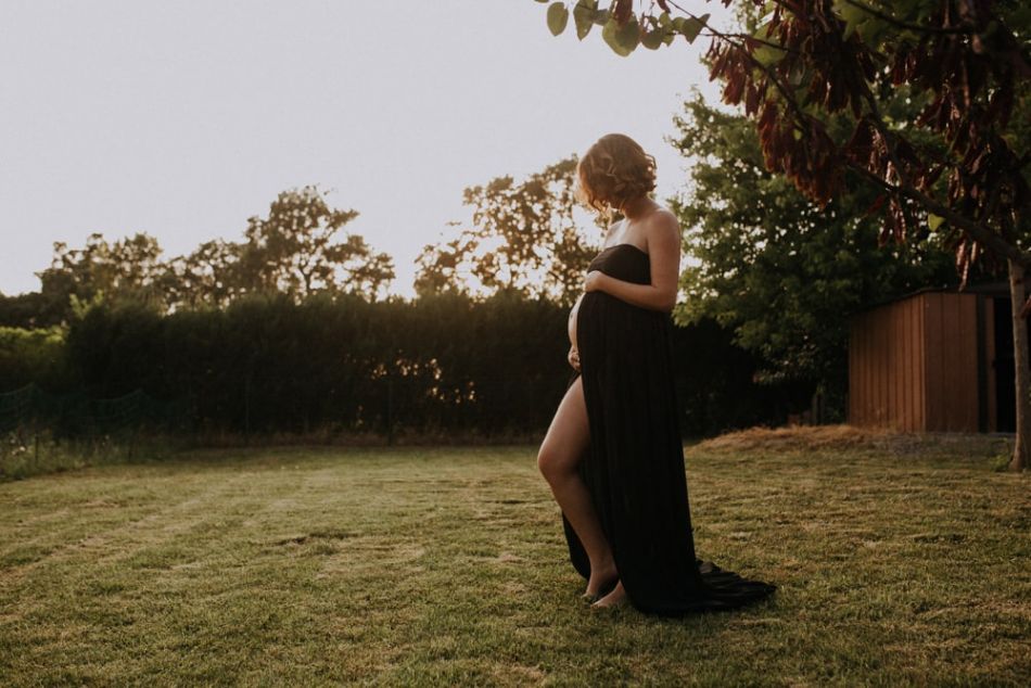 Femme enceinte en robe noire en séance photo grossesse à Gimont
