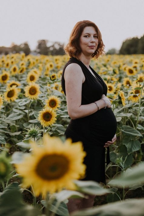 Femme enceinte au milieu des tournesols en séance grossesse à Gimont