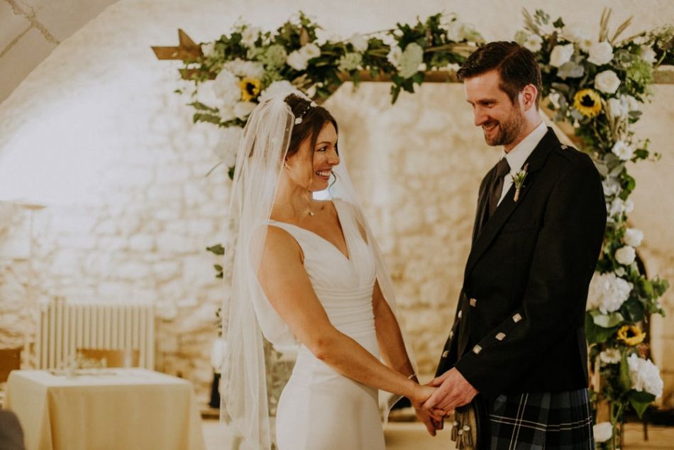 Mariés sous une arche fleurie au château de la Côte dans le Périgord
