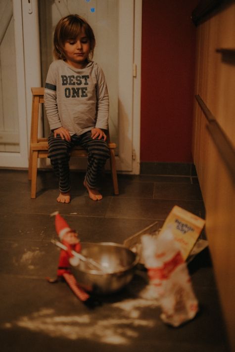 un enfant devant le lutin de Noël et sa bêtise